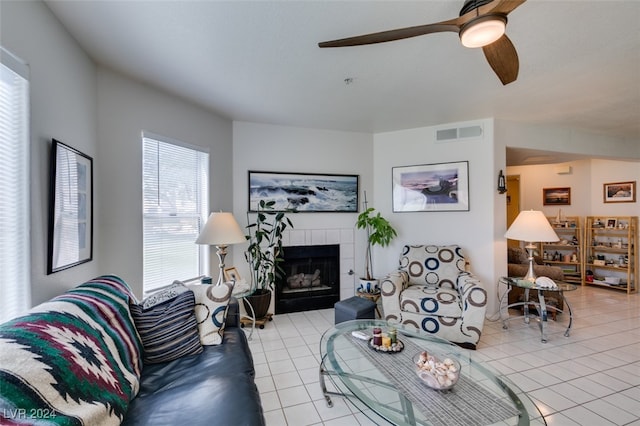 living area with a ceiling fan, visible vents, a fireplace, and tile patterned floors