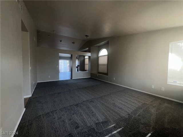 carpeted spare room with vaulted ceiling