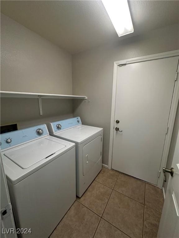 laundry area featuring separate washer and dryer and light tile patterned floors