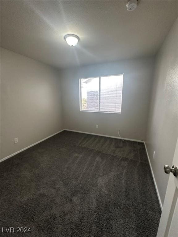 carpeted empty room featuring a textured ceiling