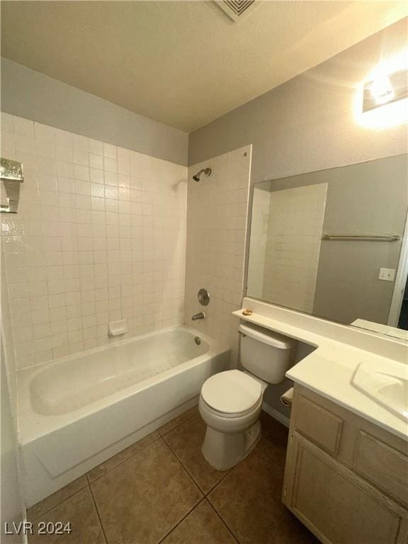 full bathroom featuring tile patterned floors, toilet, tiled shower / bath combo, and vanity