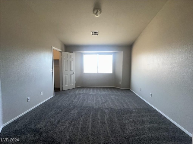 unfurnished room featuring dark colored carpet