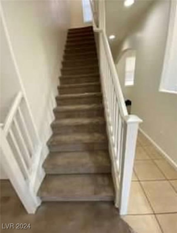 stairway with tile patterned floors