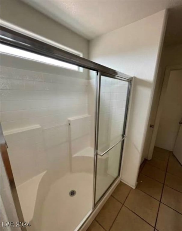 bathroom featuring an enclosed shower and tile patterned floors