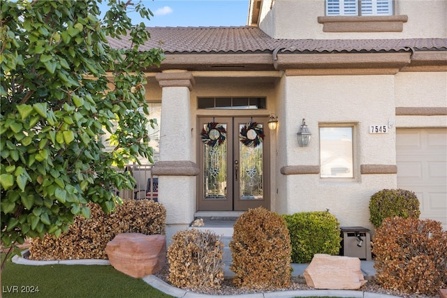 doorway to property with a garage and french doors