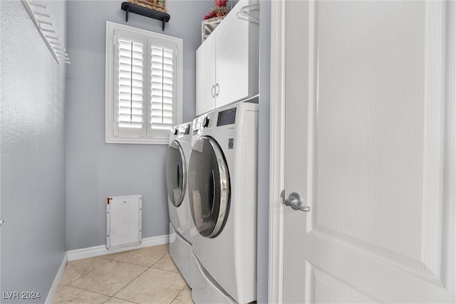 laundry room featuring light tile patterned floors, cabinets, and washer and dryer