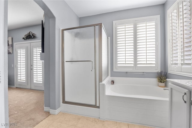 bathroom featuring plus walk in shower, vanity, and tile patterned floors