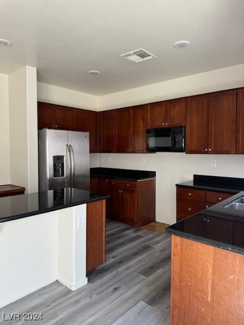 kitchen with sink, a textured ceiling, dark wood-type flooring, and stainless steel refrigerator with ice dispenser