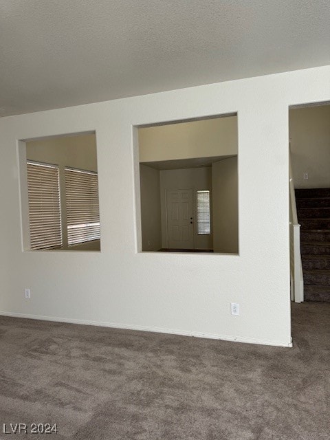 carpeted spare room featuring a textured ceiling