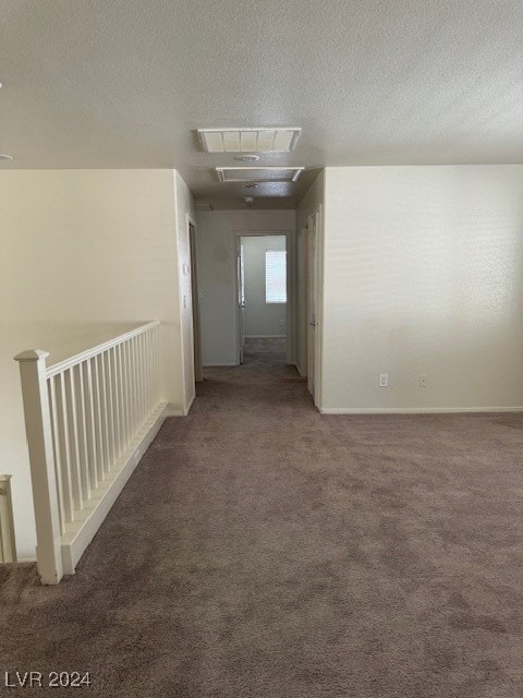 hall with carpet and a textured ceiling