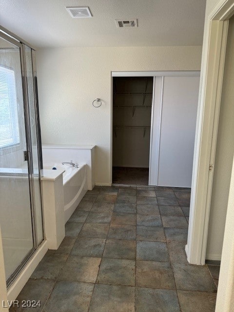 bathroom featuring tile patterned flooring and plus walk in shower