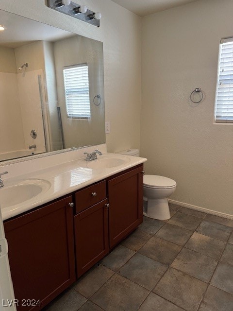 bathroom featuring toilet, double sink vanity, and tile patterned flooring