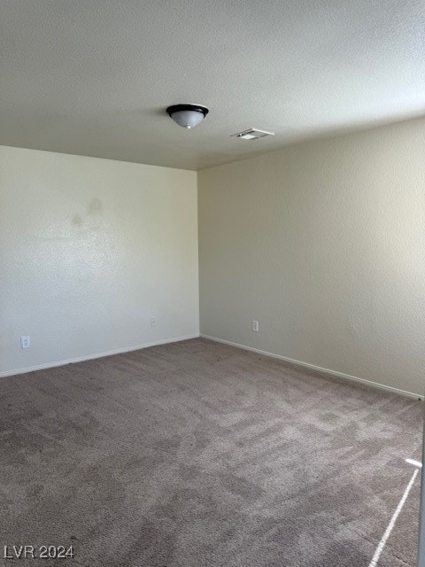 carpeted spare room with a textured ceiling