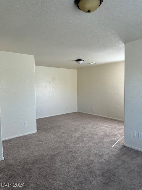 carpeted empty room with a textured ceiling