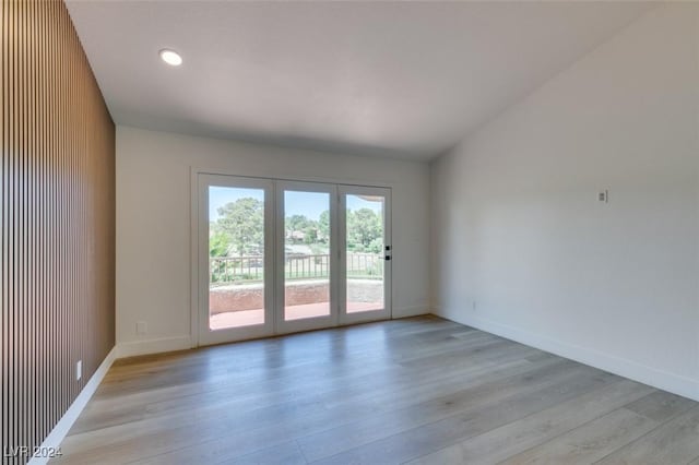 unfurnished room featuring recessed lighting, light wood-style flooring, baseboards, and vaulted ceiling