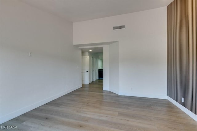 unfurnished room with visible vents, light wood-style flooring, and baseboards