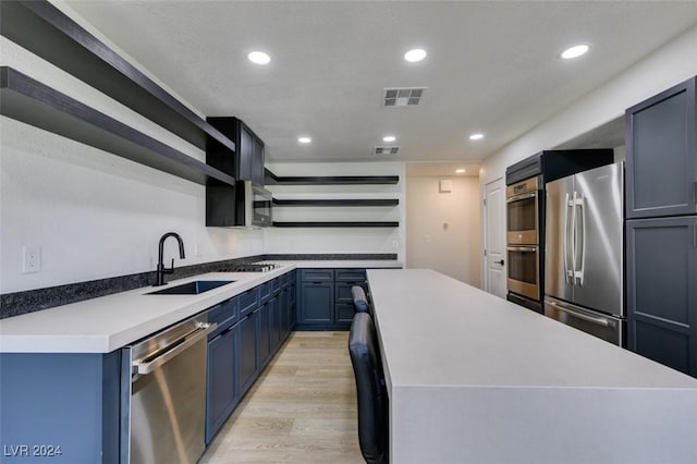 kitchen with open shelves, recessed lighting, light wood-style flooring, appliances with stainless steel finishes, and a sink