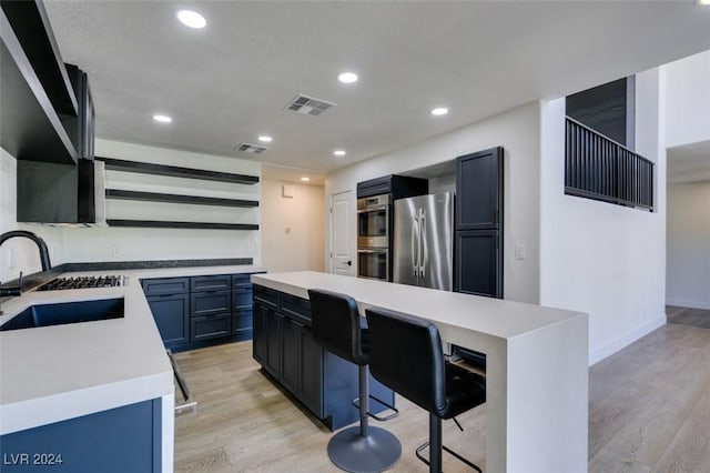 kitchen featuring visible vents, open shelves, light wood-style flooring, a sink, and stainless steel fridge