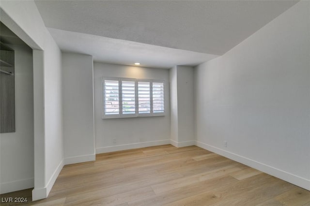 empty room featuring baseboards and light wood-type flooring