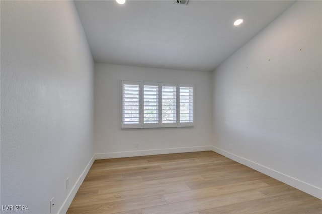 unfurnished room with recessed lighting, light wood-type flooring, baseboards, and visible vents