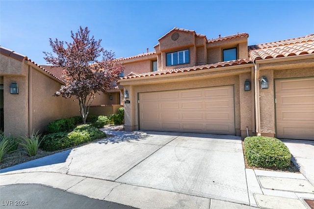 mediterranean / spanish-style home featuring stucco siding, driveway, and a tile roof