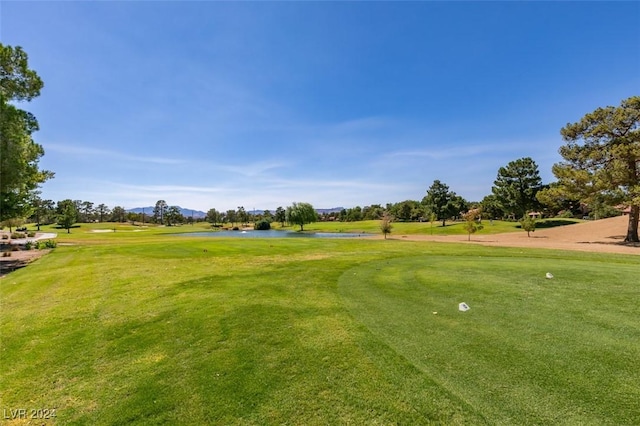 view of property's community with a yard, a water view, and golf course view