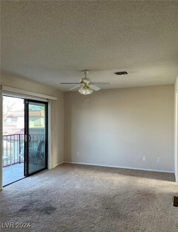 carpeted spare room featuring ceiling fan and a textured ceiling