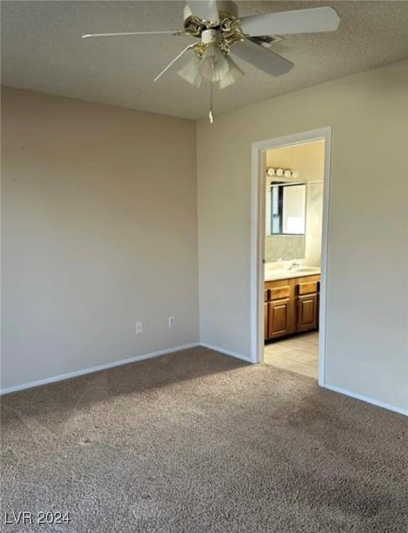 unfurnished bedroom with ceiling fan, connected bathroom, and light colored carpet