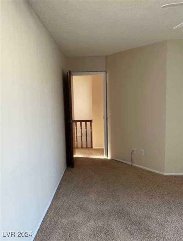 carpeted spare room with a textured ceiling