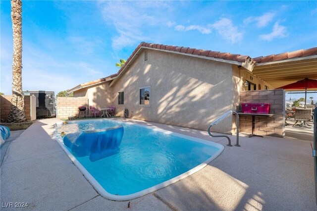 view of swimming pool featuring pool water feature and a patio area