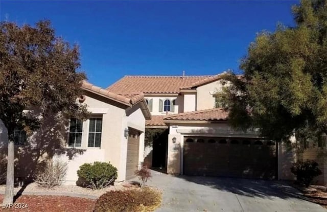 1700 Ravanusa Dr, Henderson, NV 89052 - mediterranean / spanish house with concrete driveway, an attached garage, a tile roof, and stucco siding