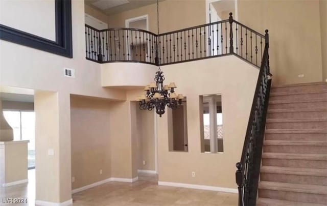 1700 Ravanusa Dr, Henderson, NV 89052 - stairs featuring an inviting chandelier, baseboards, a towering ceiling, and visible vents