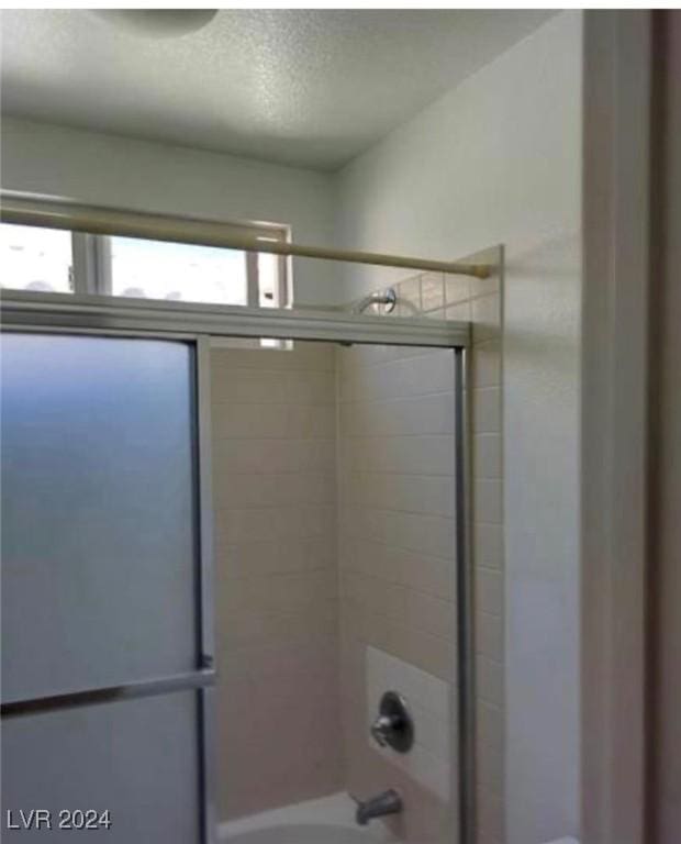 1700 Ravanusa Dr, Henderson, NV 89052 - full bath with a textured ceiling and shower / bath combination with glass door