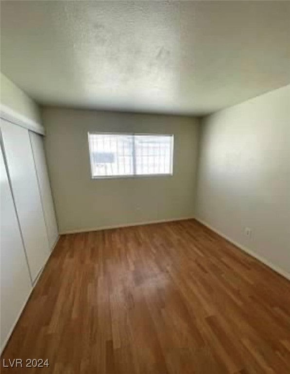 unfurnished bedroom with a closet and hardwood / wood-style floors