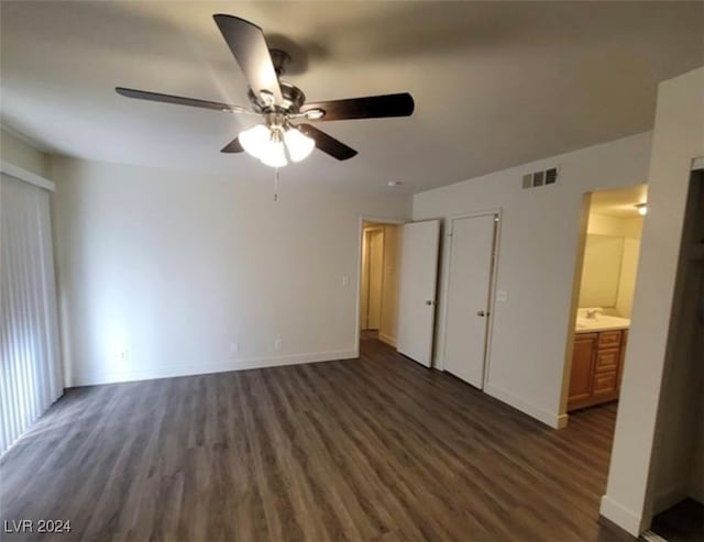 unfurnished bedroom with a closet, ceiling fan, dark hardwood / wood-style flooring, and ensuite bath