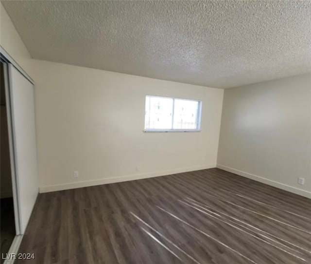 unfurnished bedroom with hardwood / wood-style floors, a textured ceiling, and a closet