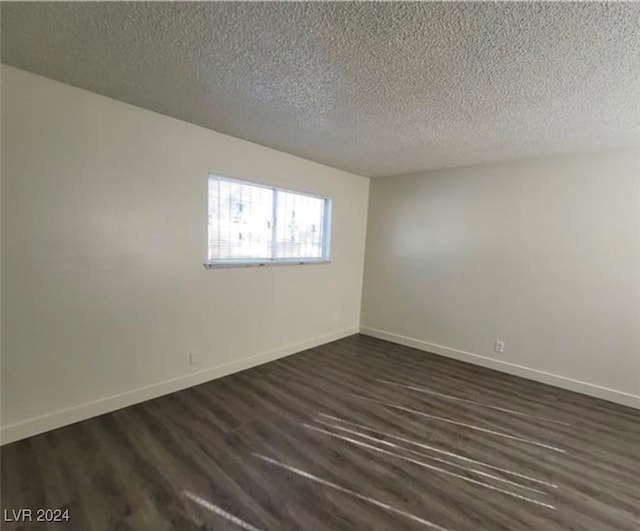 spare room featuring a textured ceiling and hardwood / wood-style flooring