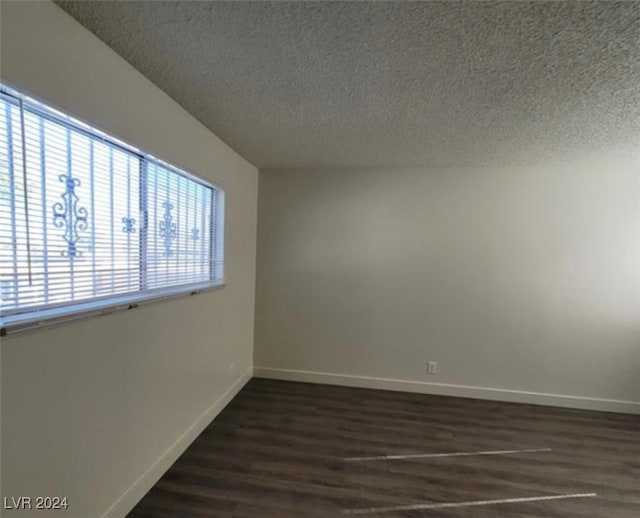 spare room featuring hardwood / wood-style floors, a textured ceiling, and a healthy amount of sunlight