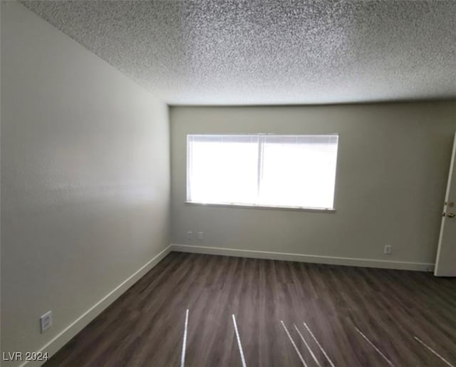 empty room featuring a textured ceiling and hardwood / wood-style flooring