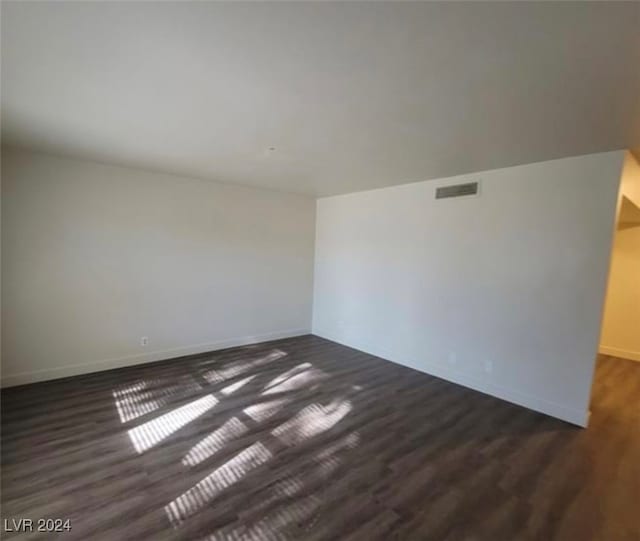 spare room featuring dark wood-type flooring