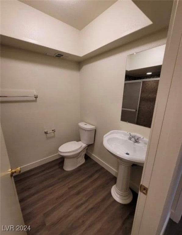 bathroom with toilet and wood-type flooring