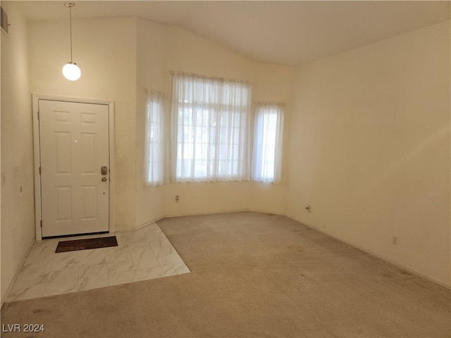 carpeted foyer entrance with lofted ceiling