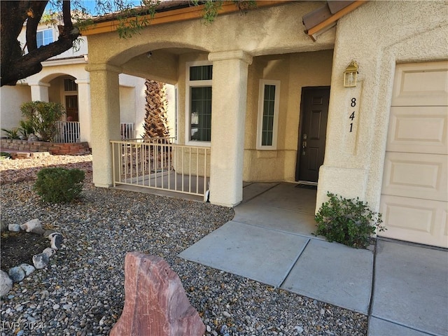 property entrance featuring a garage and covered porch