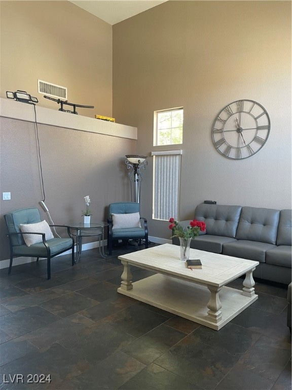 tiled living room featuring a high ceiling