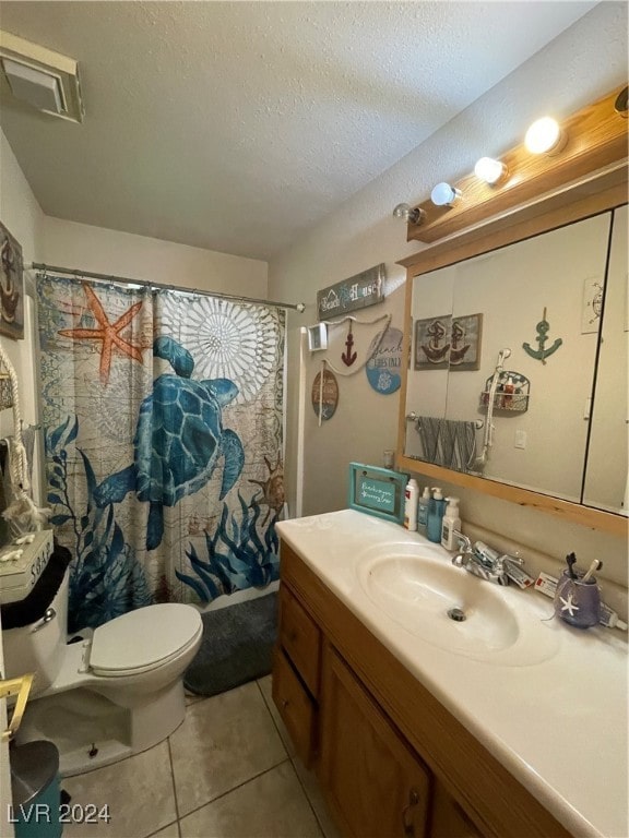 full bath featuring toilet, vanity, a textured ceiling, and tile patterned floors