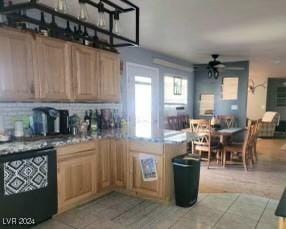 kitchen with light tile patterned floors, black dishwasher, a ceiling fan, a peninsula, and backsplash