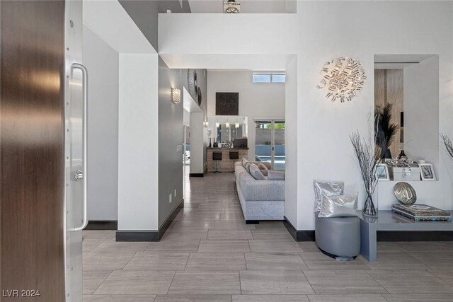 living room featuring a towering ceiling and tile patterned flooring