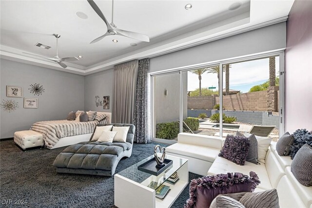 living room with ceiling fan, a raised ceiling, and carpet