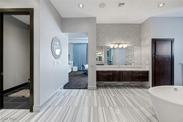 bathroom with a bath, tile patterned flooring, and vanity