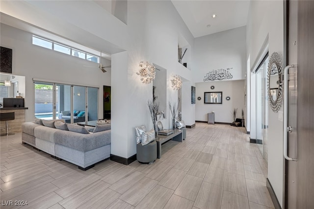 tiled living room featuring a towering ceiling and ceiling fan